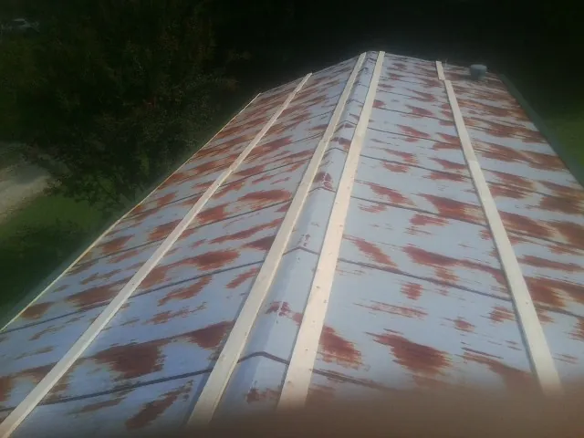 Rusted metal roof panels with new wood purlins before replacement — Storm Damage Roof Repair in White by Roofing Brothers